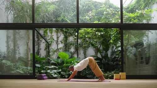 Adult Man Practicing Yoga Poses in Bright Room