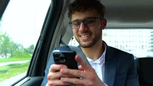 Young Adult Man Using Phone in Car