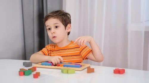 Close Up of Child's Hands Playing with Colorful Wooden Bricks at the Table Stock Footage Slow Motion