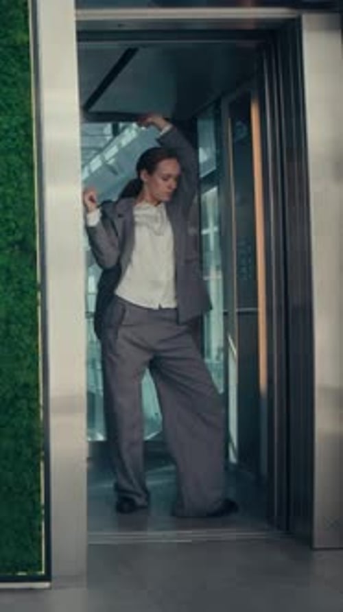 Vertical of Businesswoman Dancing in Elevator