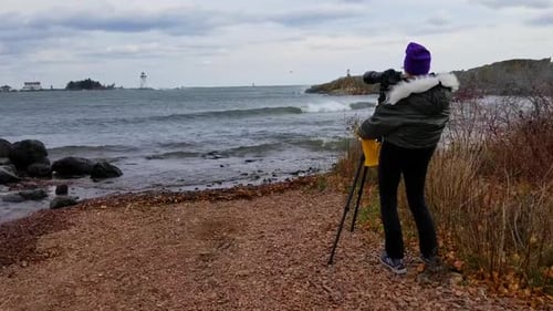 Photographer taking photos of waves on Lake Superior, Grand Marais, Minnesota