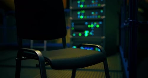 Une chaise mystérieuse se trouve dans l'ombre d'une salle de serveurs faiblement éclairée la nuit