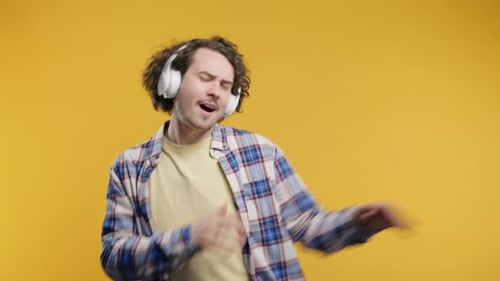 Happy Positive Man Listening Music Enjoying Dance with Headphonesyellow Studio