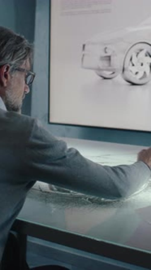 Un designer automobile dessine un prototype de voiture avec une table à écran tactile à affichage numérique