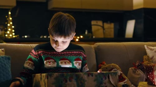 Boy Opening Glowing Christmas Present at Night