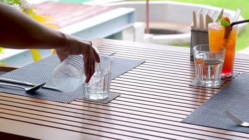 Refreshing Water Poured at Tropical Outdoor Table