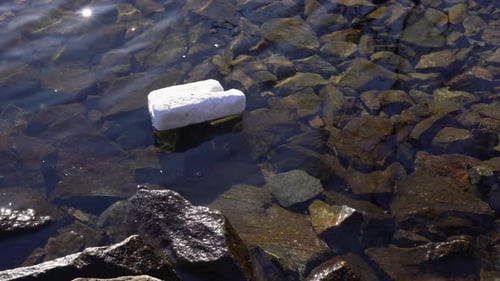 Old piece of styrofoam floating in Norway fjord, polluting water.