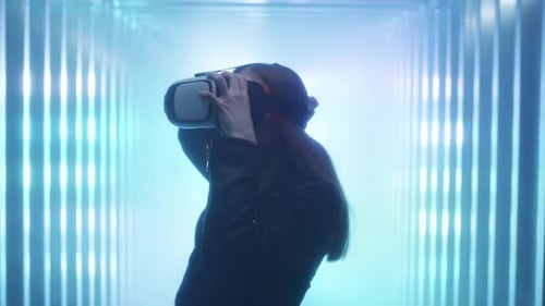 The Girl Holds Virtual Reality Glasses in Her Hands Puts Them on Her Head