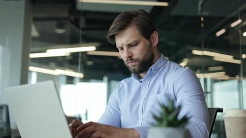 Focused Businessman Working on Laptop in Office