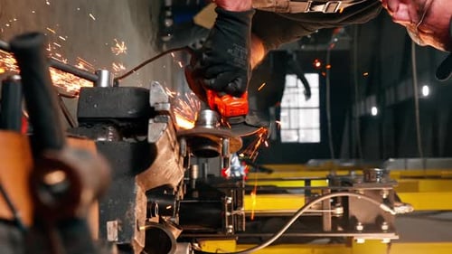 Vertical Video Closeup of Car Mechanic Working at a Service Station with an Angle Grinder From Which