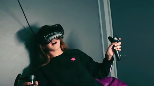 Young Woman Uses Virtual Reality Headset and Controllers