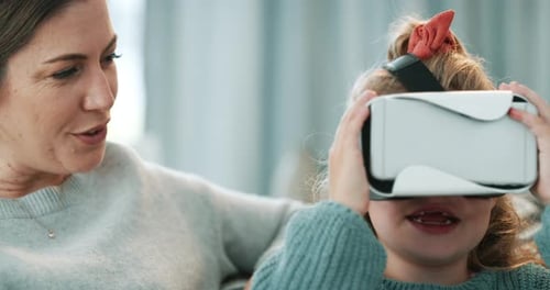 Girl uses Virtual Reality Headset with Woman Indoors