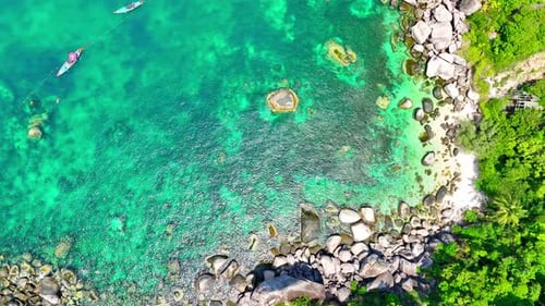 Stunning sandy beach with rock and clean sea water by aerial view. 4K.