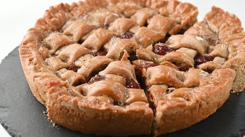 Freshly baked cherry pie on black slate board