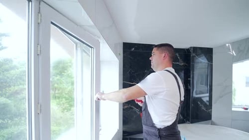 worker installs and adjusts a new plastic window in house. repair regulates Installation