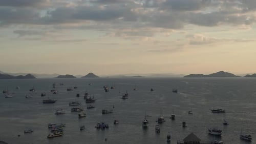 Vista marítima en lapso temporal de la puesta de sol y de muchos barcos en la costa del puerto de Labuan Bajo.