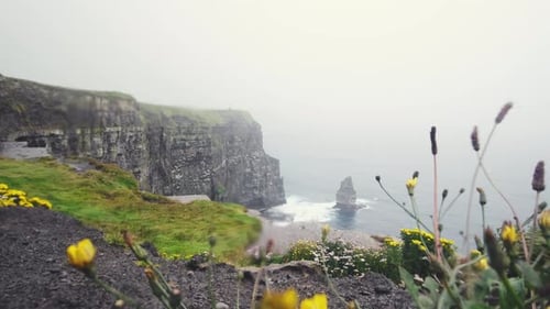 Landscape view along the coastline of the famous Cliffs of Moher on a windy and rainy day, Ireland