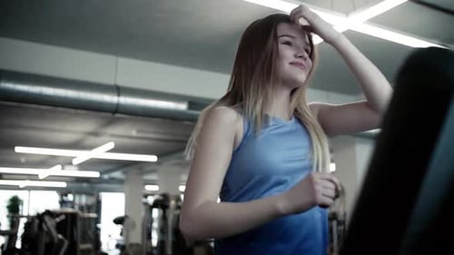 Young woman's cardio workout on a treadmill at the gym a portrait of fitness