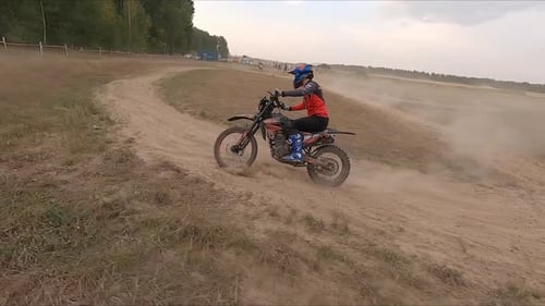 Man Rides Sportive Motorcycle Leaving Dust Trail Along Road