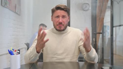 Man Gesturing While Talking in Modern Office