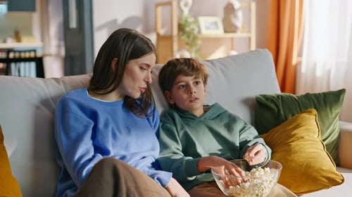 Woman and Boy Bonding on Couch with Popcorn