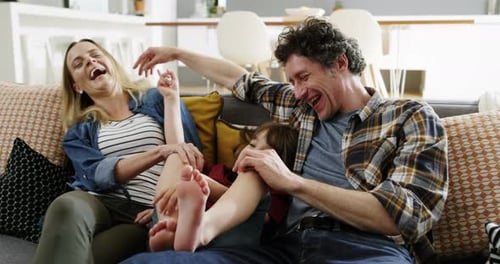Family Laughing Together on Gray Sofa at Home