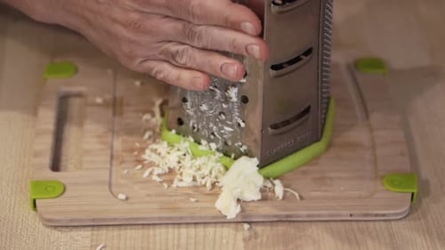 Man makes pizza at home and slicing ingredients
