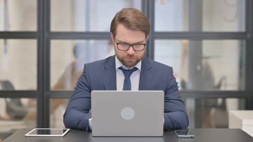 Man Typing on Laptop in Bright Modern Office