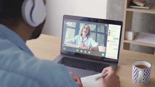 Man Attends Online Meeting and Takes Notes