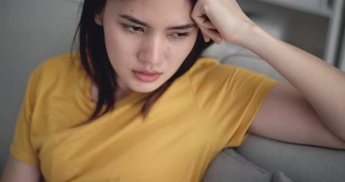 Young Woman Coughing on Couch Indoors