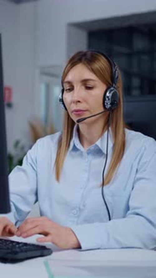Focused Female Customer Support Representative Working at Computer with Headset Providing Remote