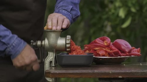 Making vegetable sauce. Mechanical grinding of paprika, sweet bell peppers and hot pepper chilli