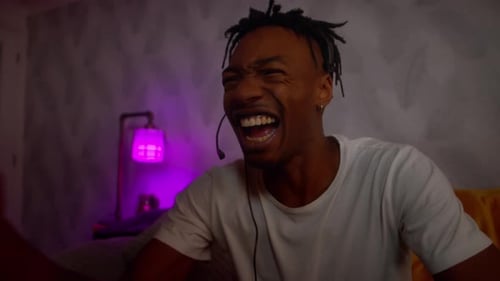 Enthusiastic Young Adult Playing Video Games at Home