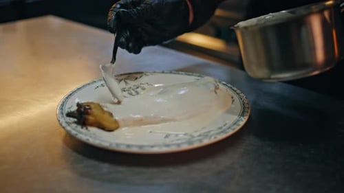 Fish Fillet Being Dressed with Sauce in Kitchen