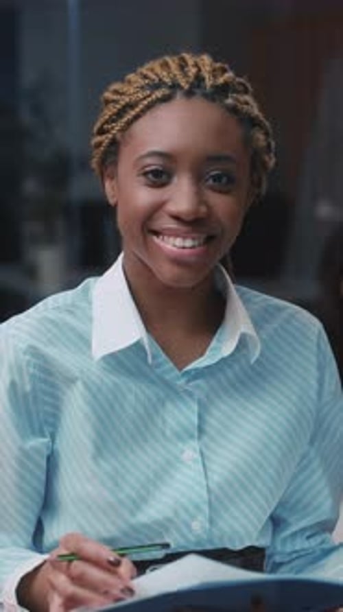 Smiling Young Adult Woman with Folder and Pen