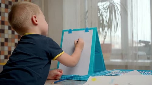 Child Drawing on Easel at Home