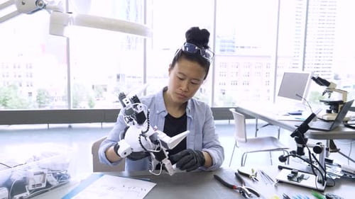 Científica ensamblando robótica en un laboratorio de ciencias para adultos