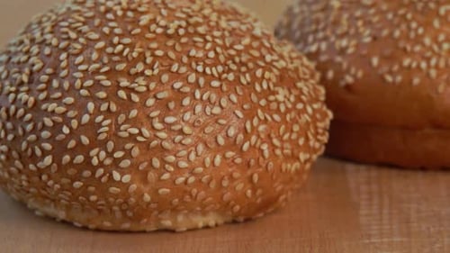 Sesame Seed Buns Resting on Wooden Surface