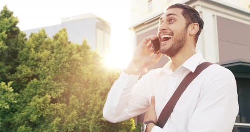 4k video footage of a handsome young businessman using a mobile phone in the city
