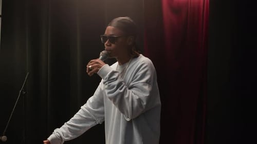 Young Black Rapper Performing on Stage with Microphone