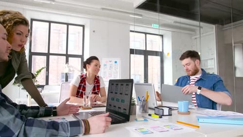 Creative team of designers collaborating on user interface in modern office