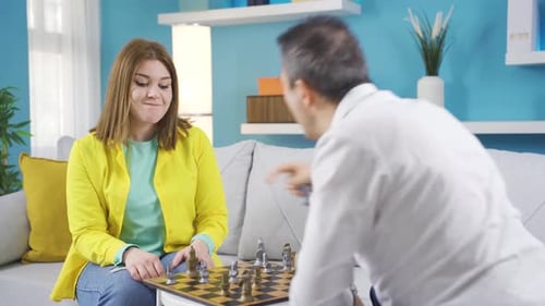 Woman Playing Chess with Man in Cozy Home