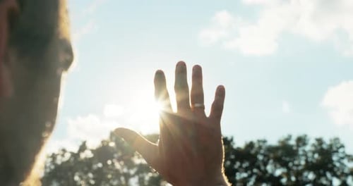 Back View of Handsome Adorable Older Man Holding Hand Against Beautiful Sunset Looking at Sun in