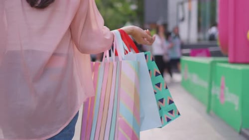 Close up of young woman shopping goods outdoor in department store.