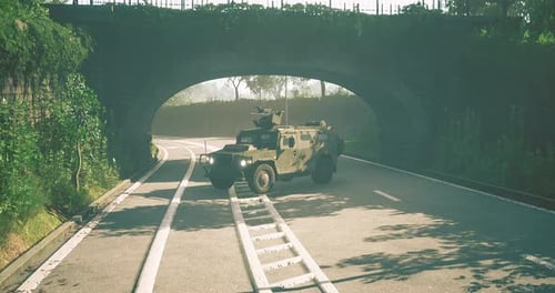 Military Vehicle Navigates Winding Road Under Charming Stone Arch Bridge