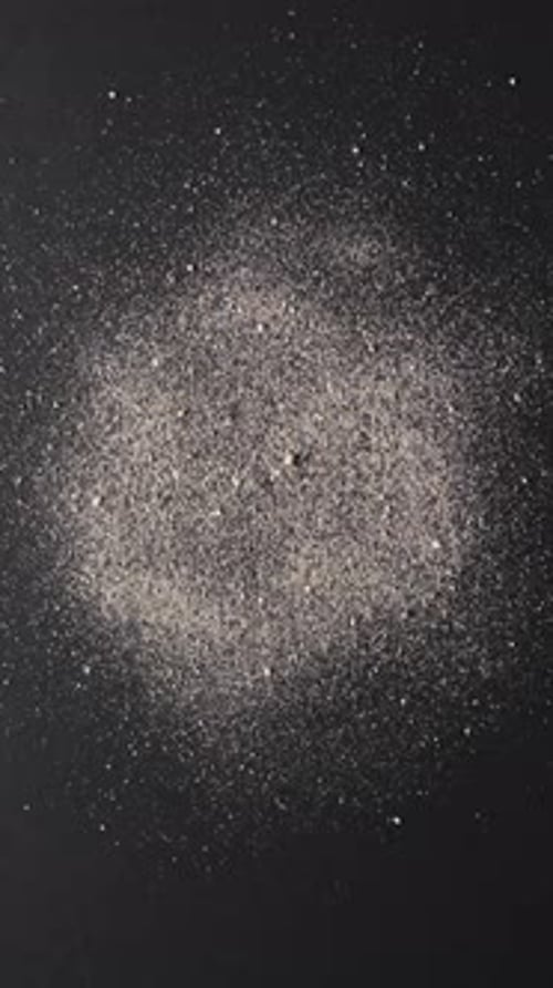 Vertical video of close up of sand grains and copy space on black background