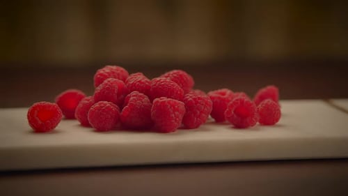 Close up of Fresh, Red Raspberries on Board