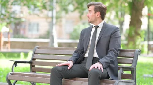 Man in Suit Waiting on Park Bench