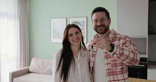 Happy Couple Owners of a New Apartment Show the Key Looking at the Camera Buying First Family Real