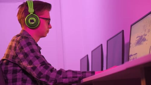 Young Adult Gamer Playing Computer Game at Desk